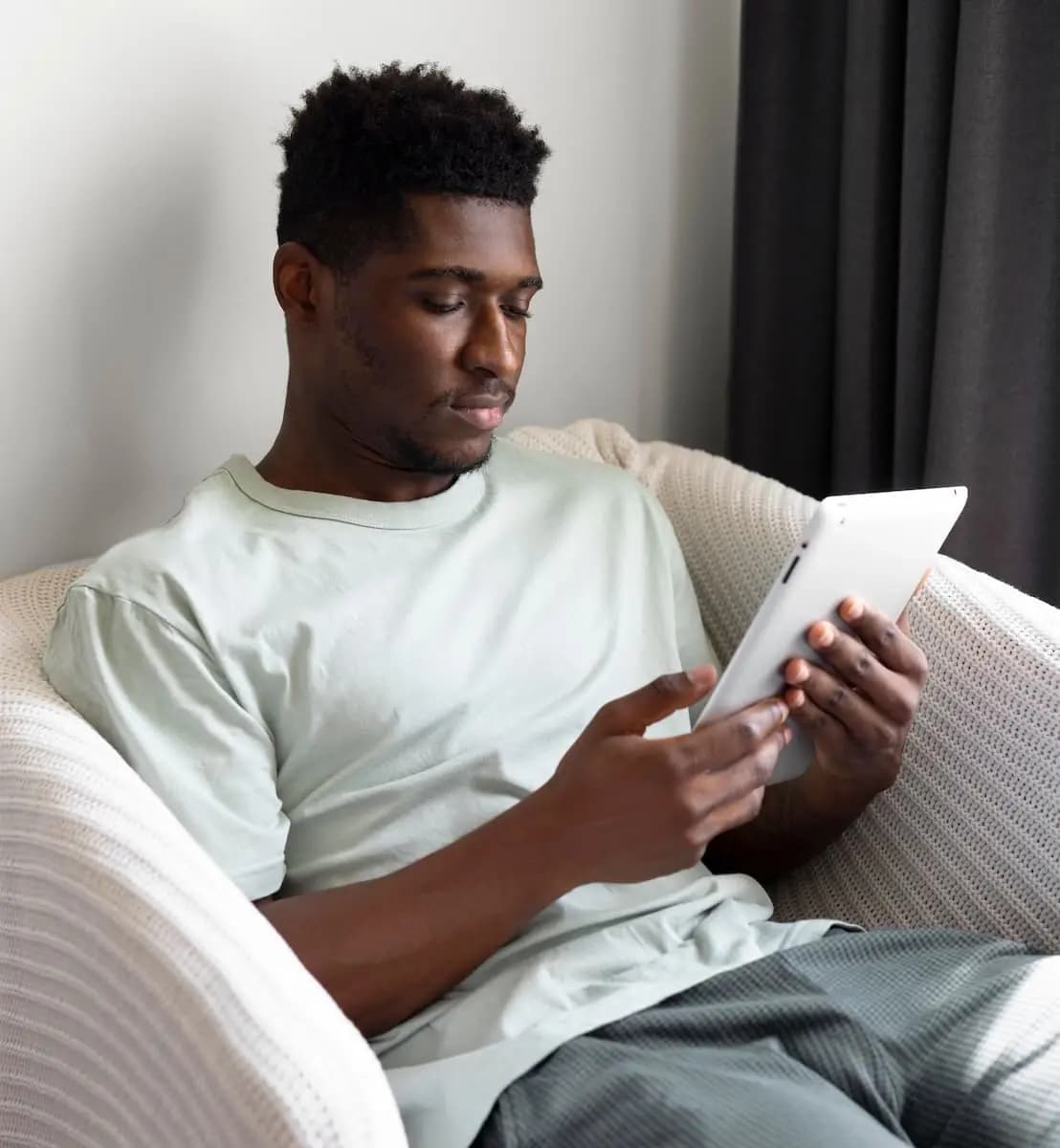 Young man sitting down with a tablet